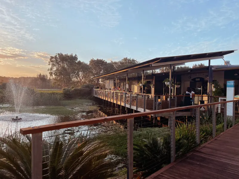 Guests dining on the DBar deck beside the lake at sunset