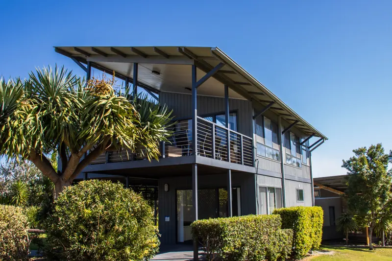Town house exterior with balcony and landscaped garden